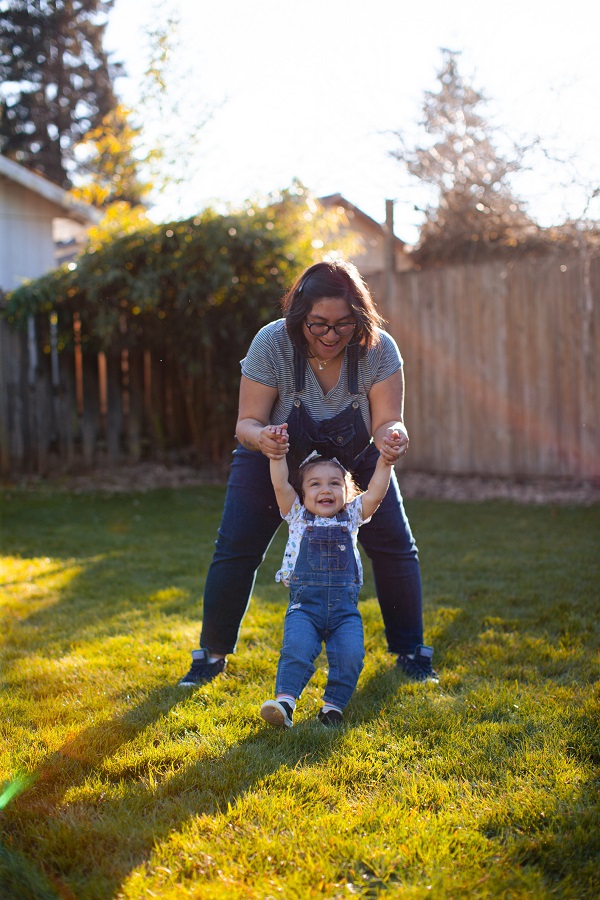 Mother And Daughter Play Together In Back Yard